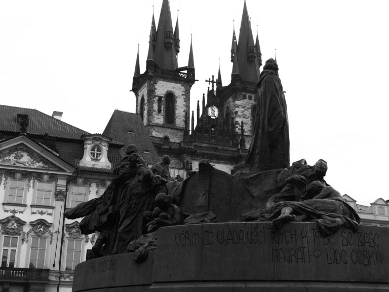 vista em preto e branco da escultura de Jan Hus na praça da cidade velh